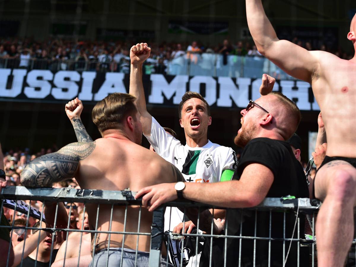 Patrick Herrmann steht in der Borussia-Kurve und jubelt.