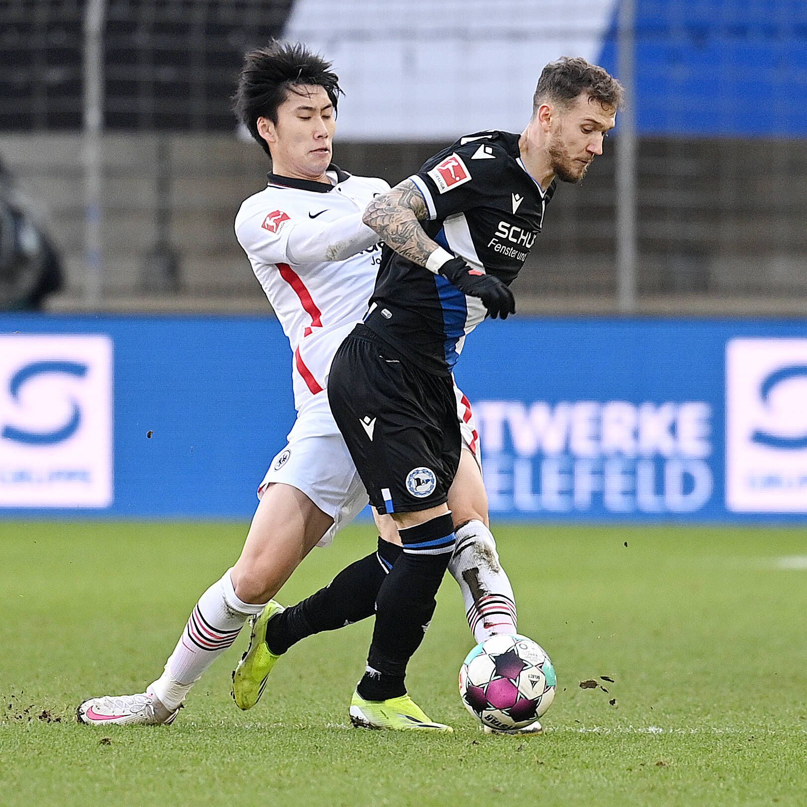 Daichi Kamada im Zweikampf mit Marcel Hartel.