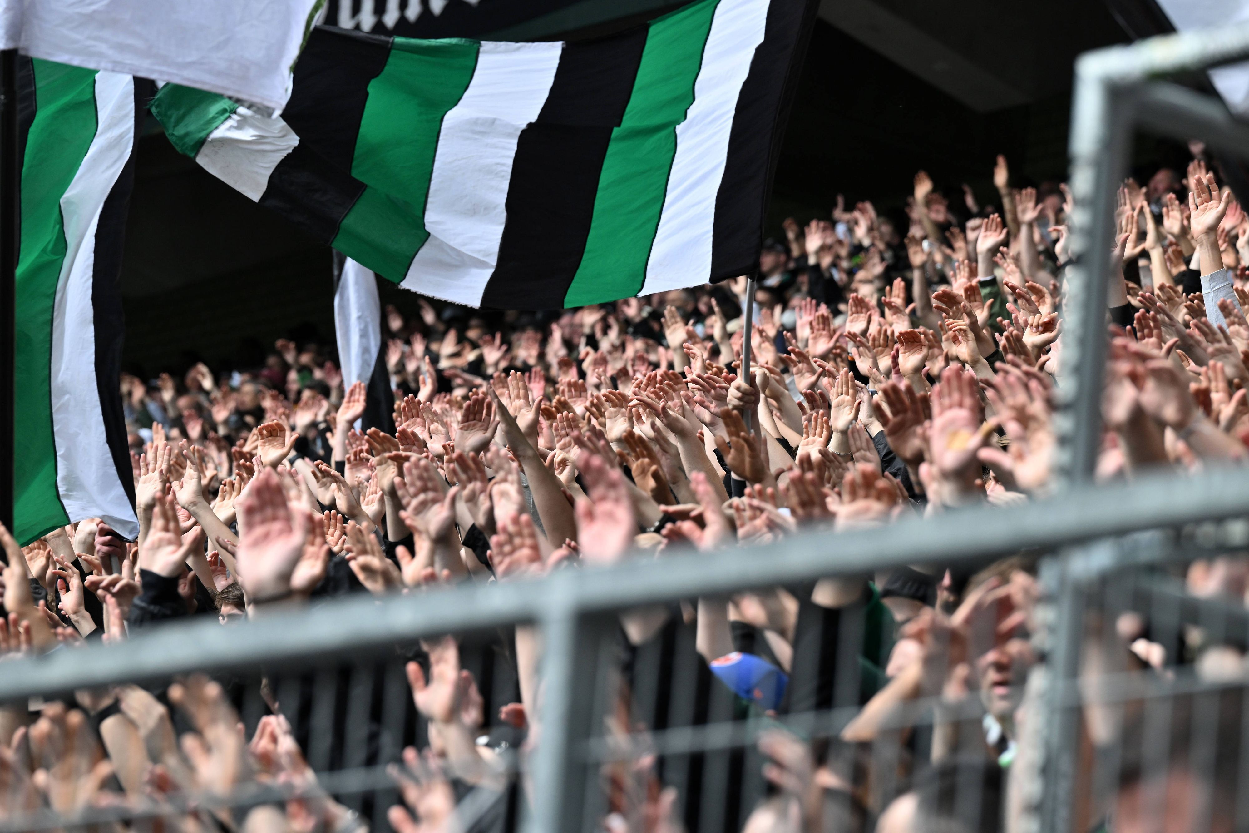 Borussia-Fans in der Nordkurve reißen die Hände nach oben.