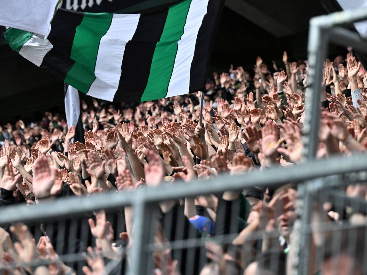 Borussia-Fans in der Nordkurve reißen die Hände nach oben.