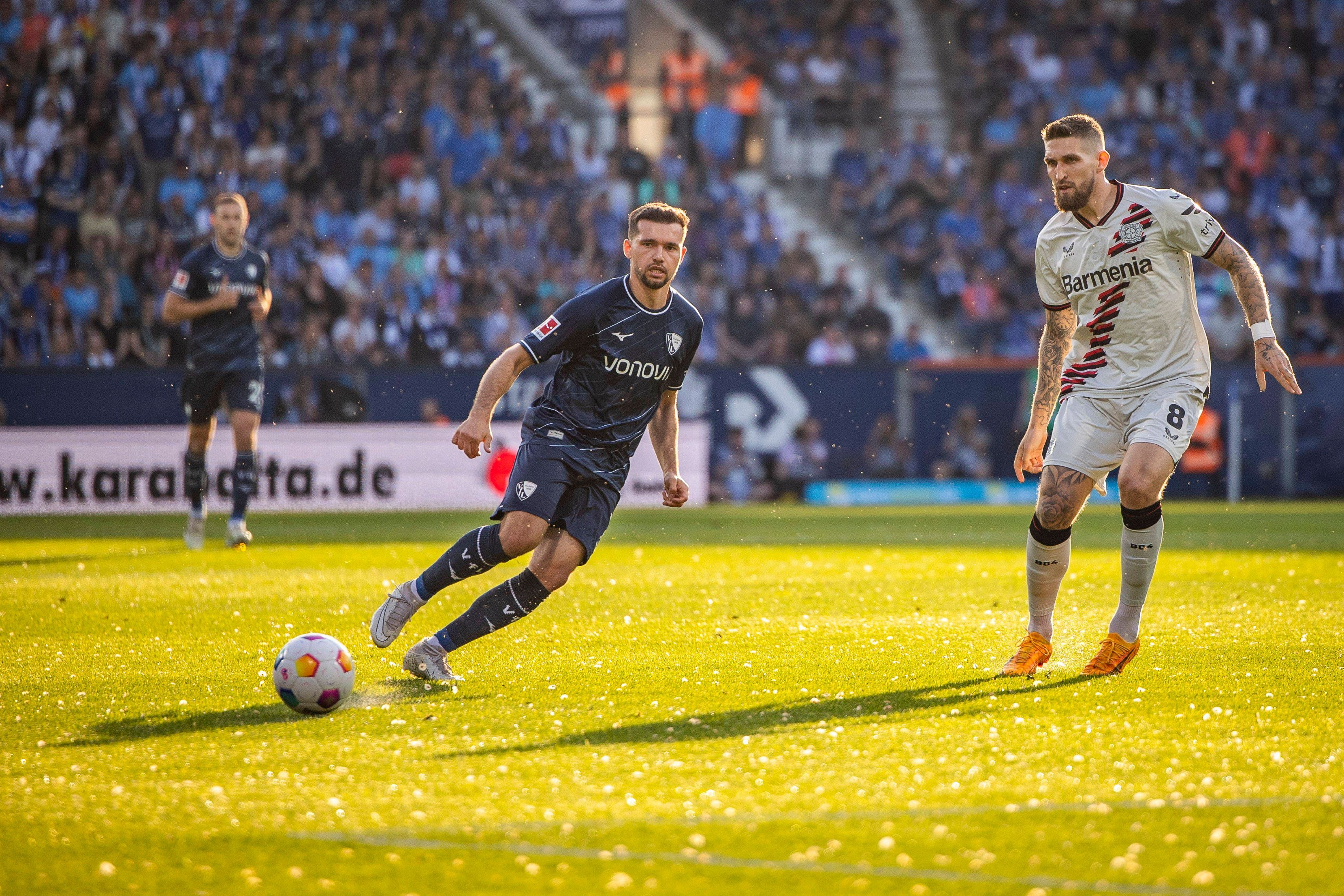 Kevin Stöger spielt einen Ball, Robert Andrich schaut zu.