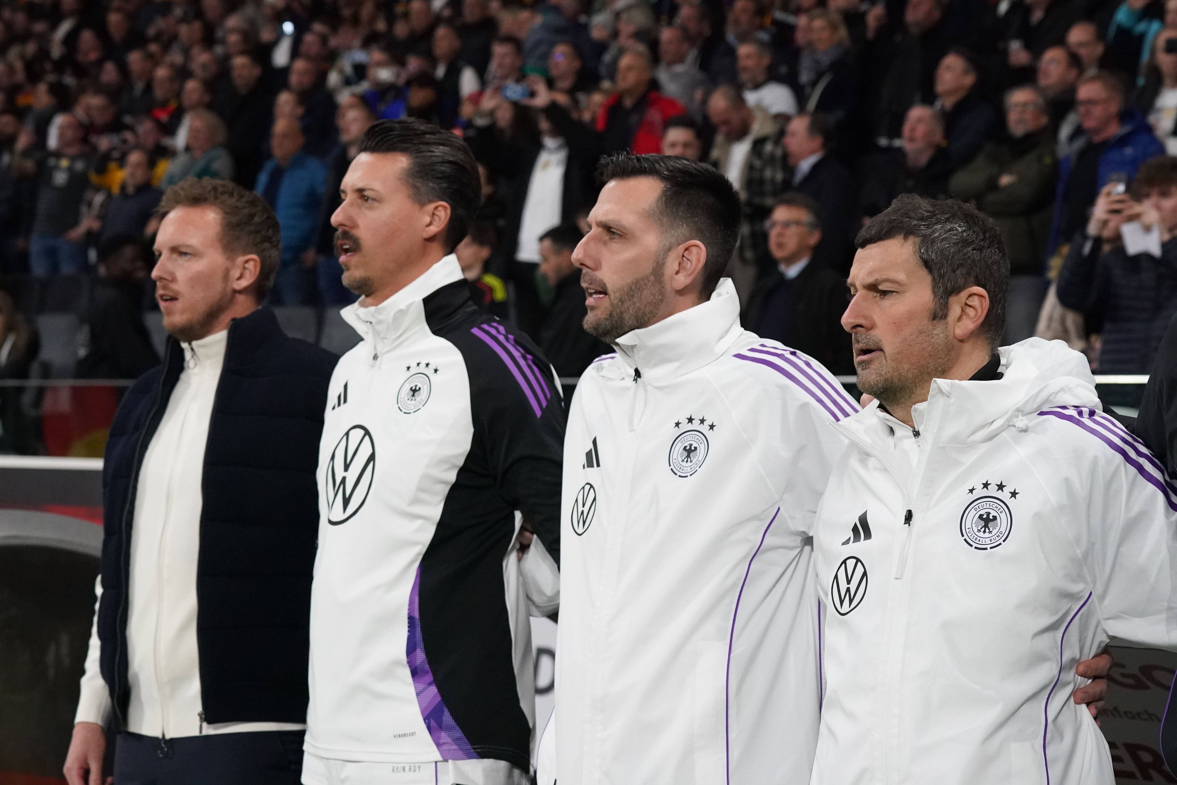 Das Trainerteam des DFB bei der Hymne.