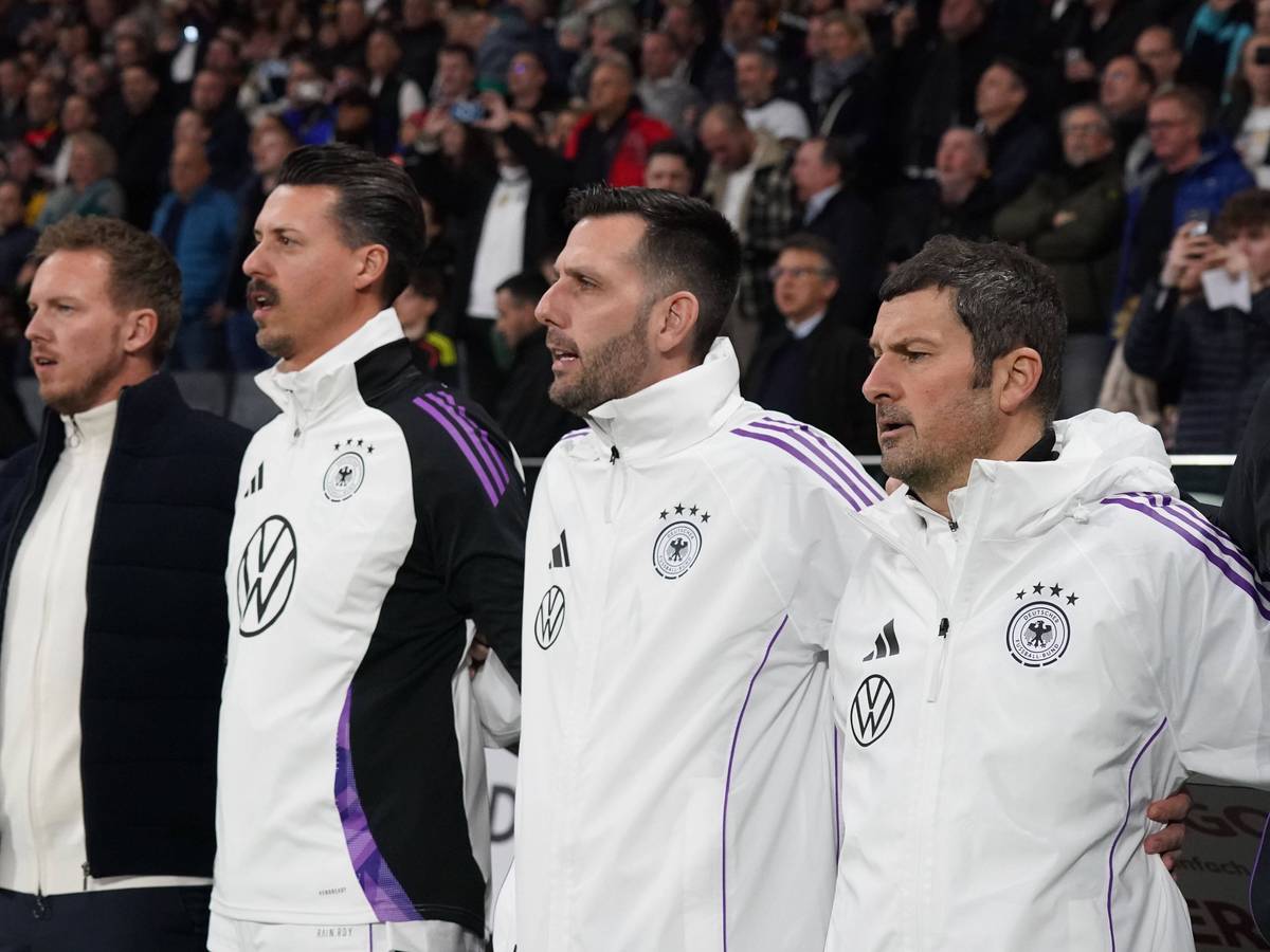 Das Trainerteam des DFB bei der Hymne.