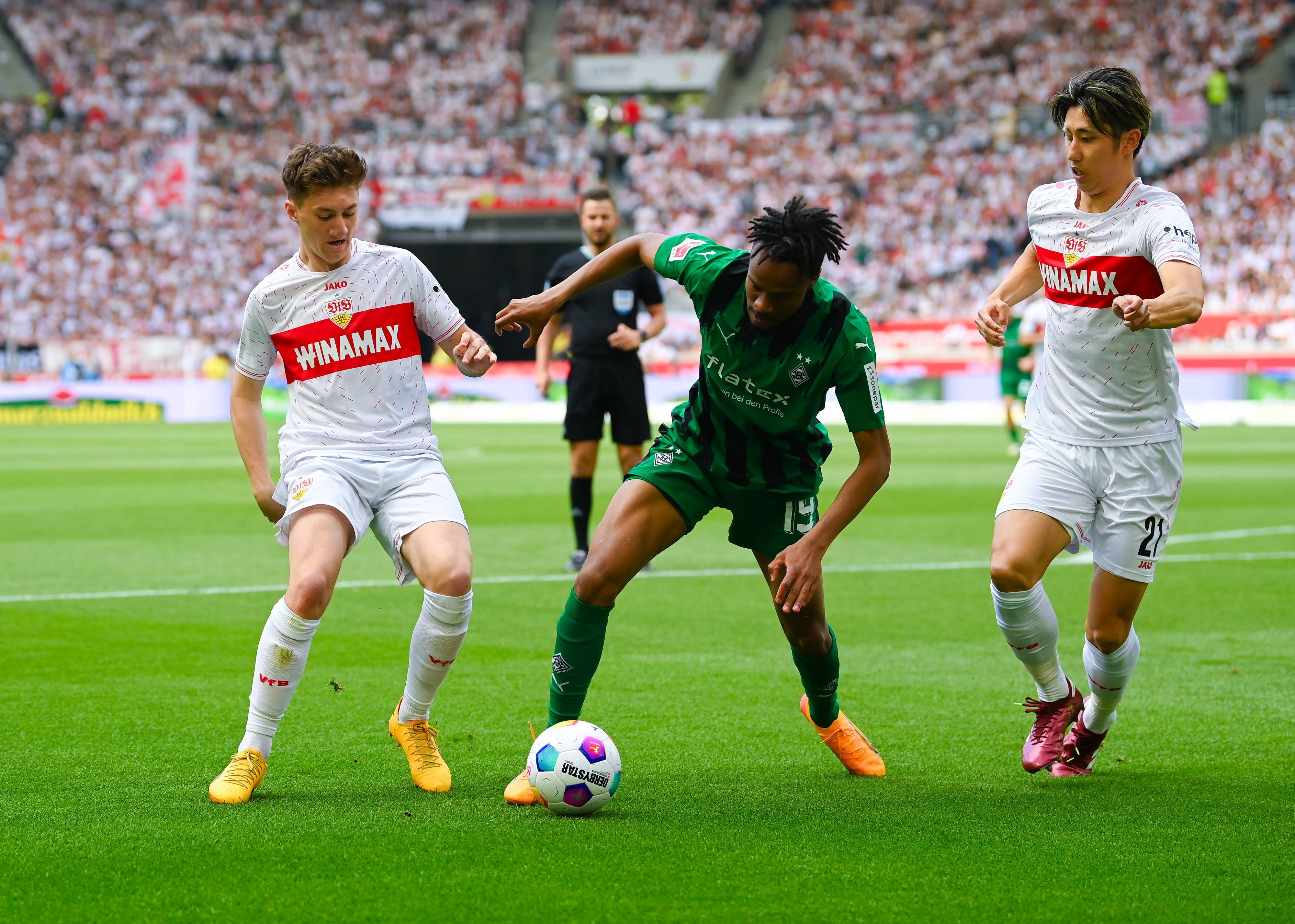 Nathan Ngoumou gegen zwei Stuttgart-Spieler.