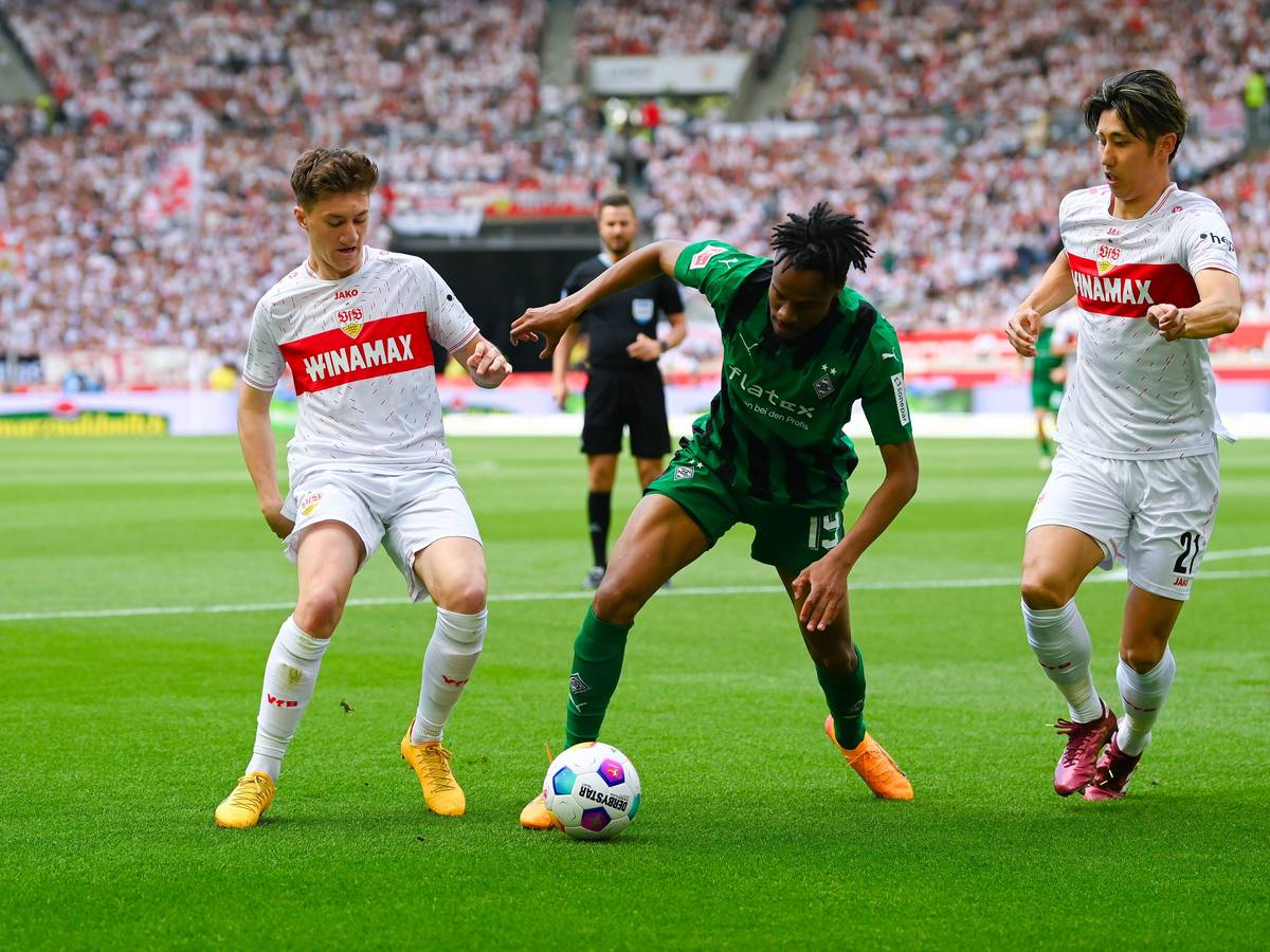 Nathan Ngoumou gegen zwei Stuttgart-Spieler.