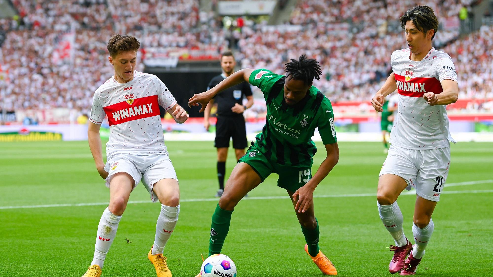 Nathan Ngoumou gegen zwei Stuttgart-Spieler.