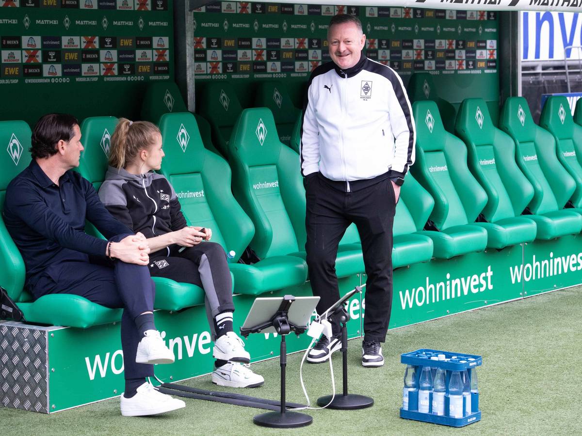 Roland Virkus lächelt, während Gerardo Seoane auf der Bank sitzt.