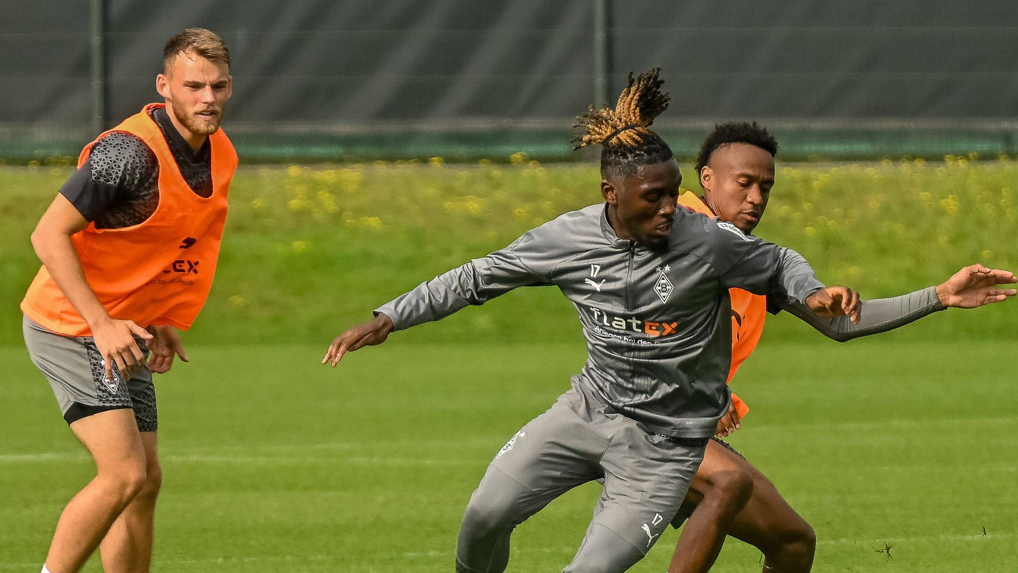 Manu Koné und Nathan Ngoumou im Kampf um den Ball, Mika Schroers schaut zu.