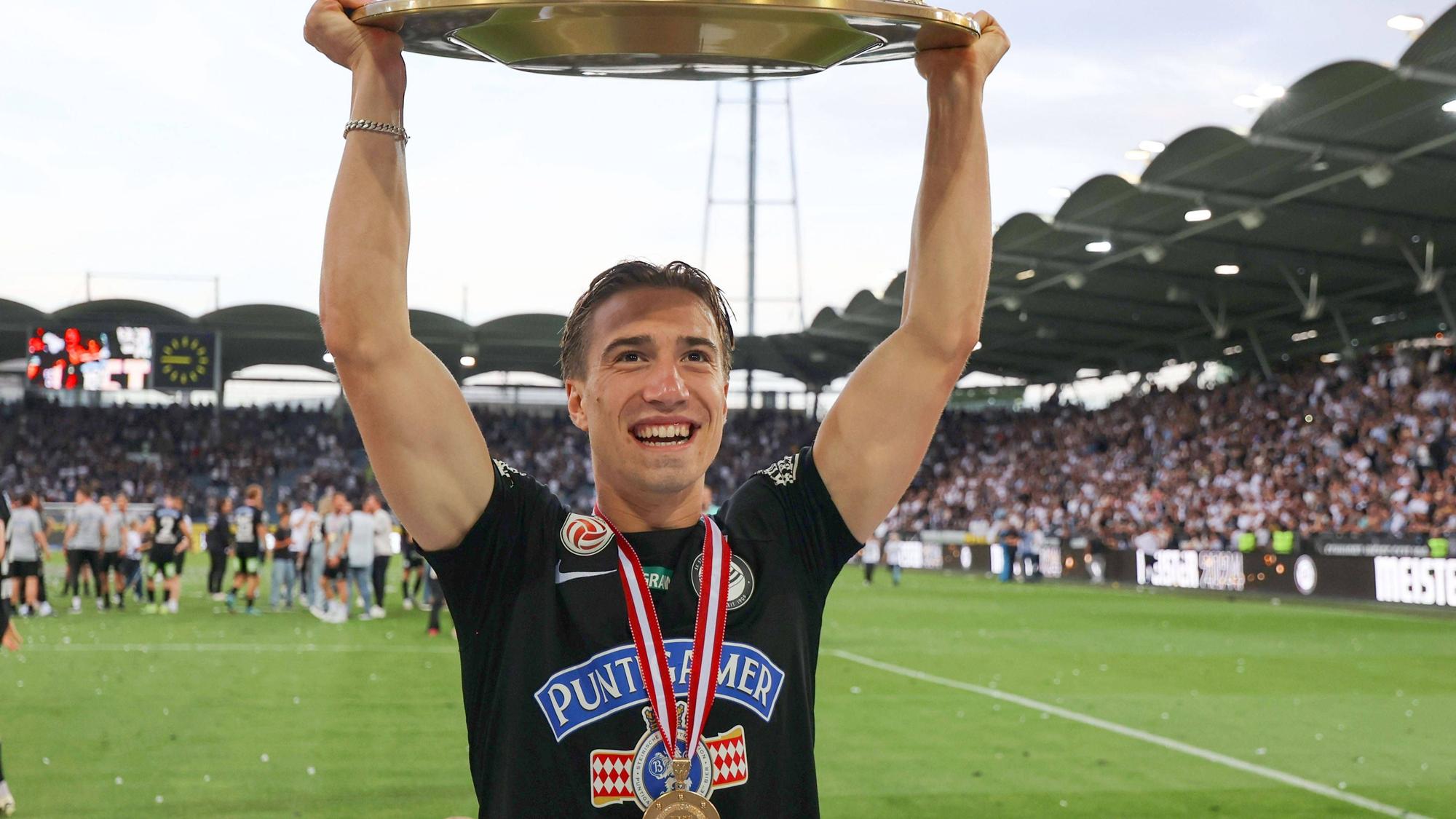David Affengruber mit der Meisterschale in der Hand.