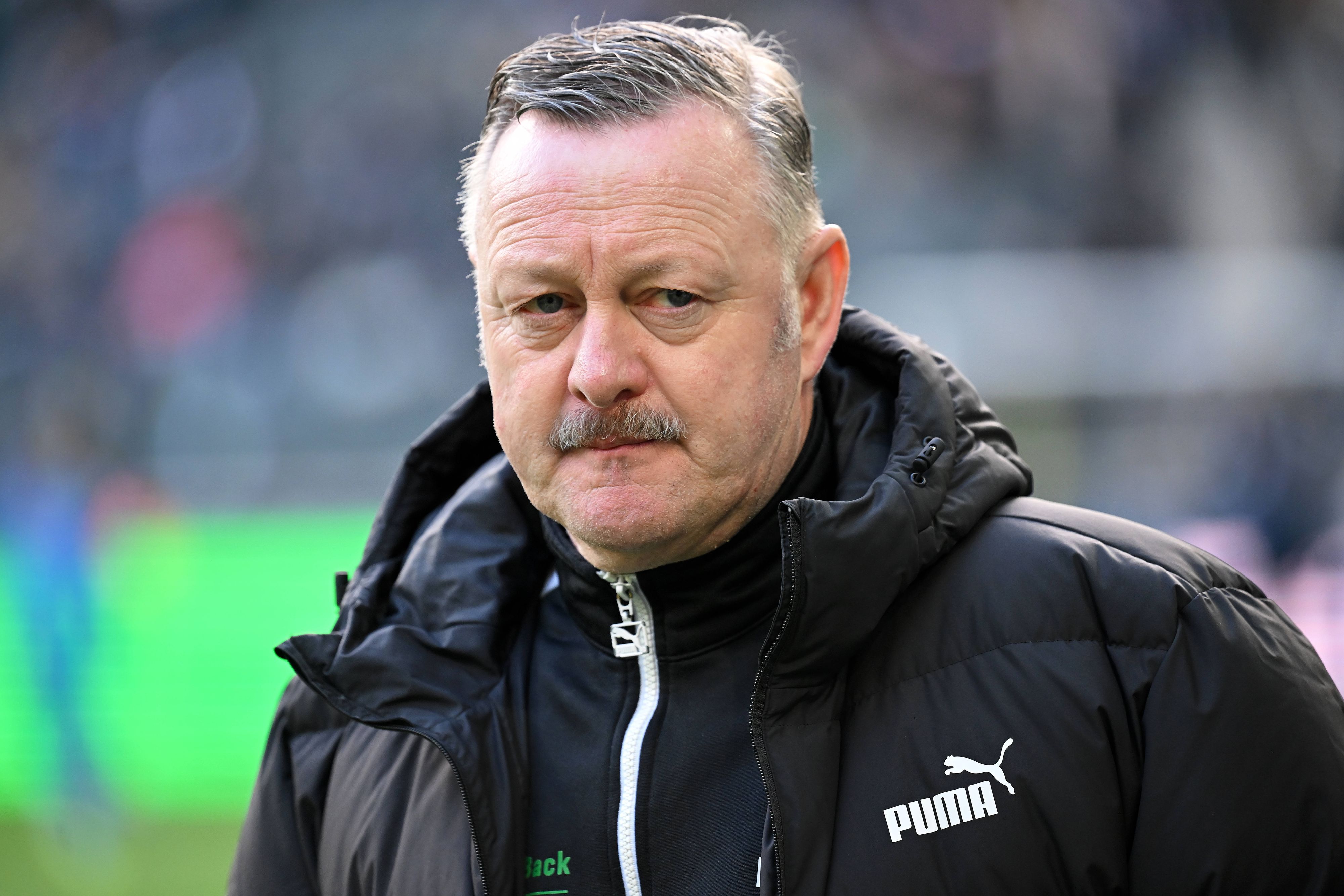 Roland Virkus in schwarzer Jacke, mit ernstem Blick.