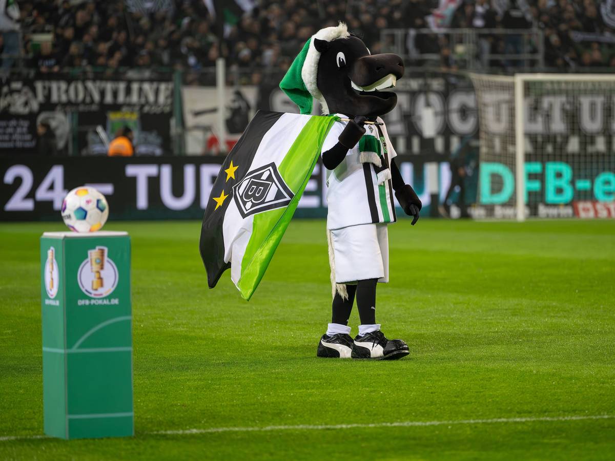 Maskottchen Jünter vor einem Sockel mit dem Pokal-Logo.