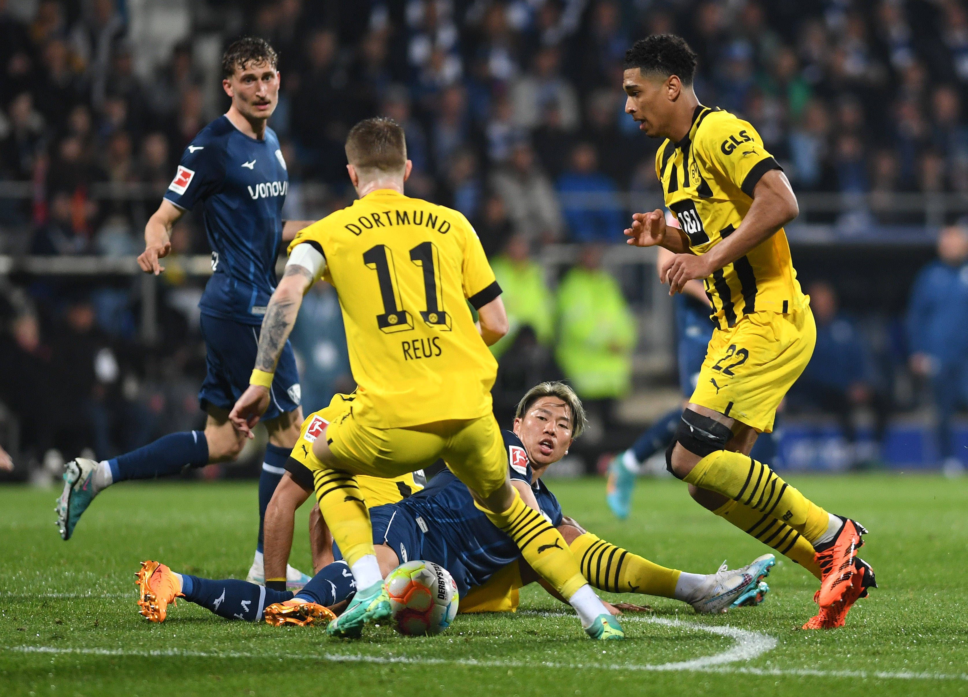 Takuma Asano grätscht einen Ball gegen Marco Reus.