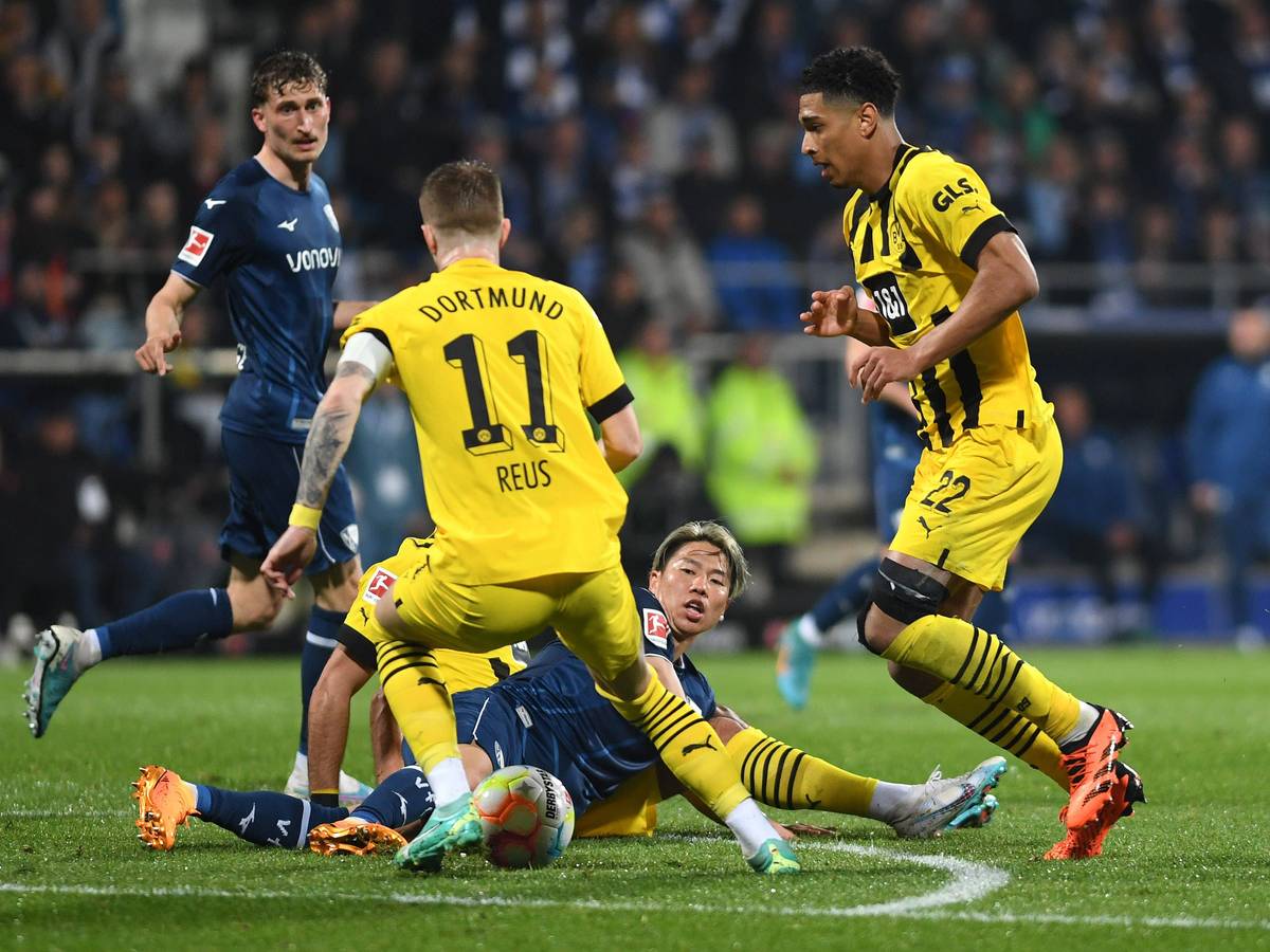 Takuma Asano grätscht einen Ball gegen Marco Reus.