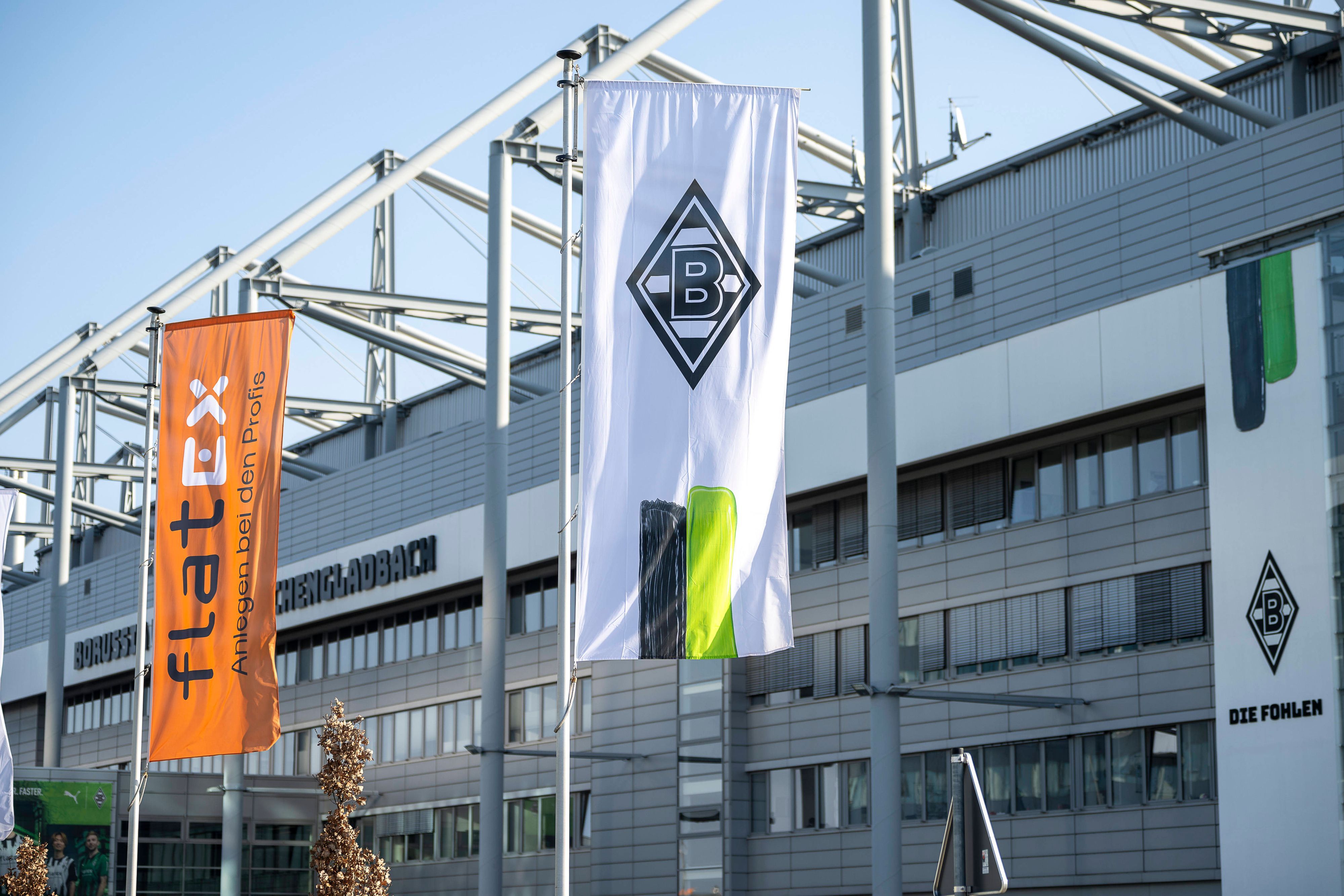 Eine Borussia-Fahne und eine Sponsoren-Flagge vor dem Borussia-Park.