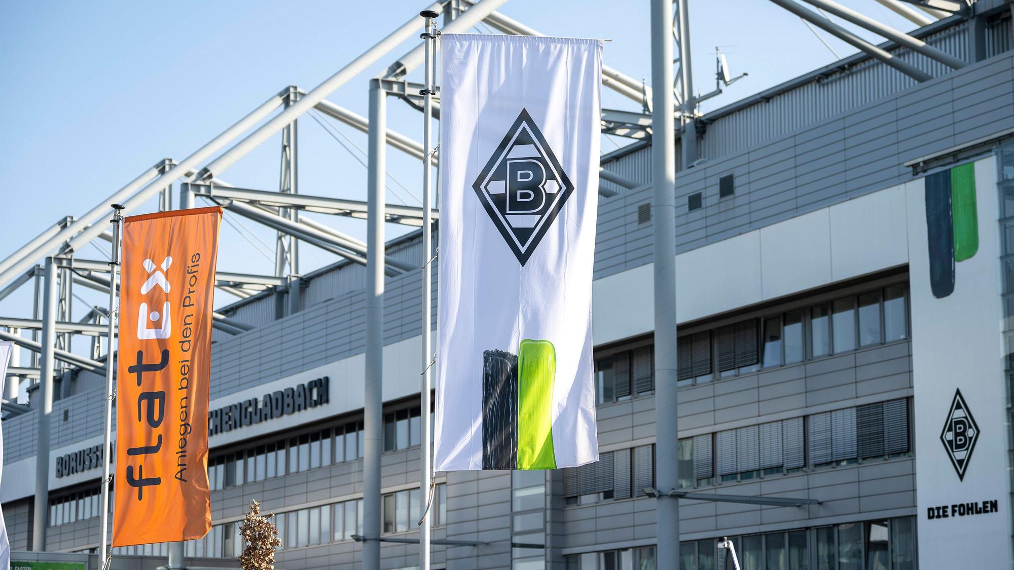 Eine Borussia-Fahne und eine Sponsoren-Flagge vor dem Borussia-Park.