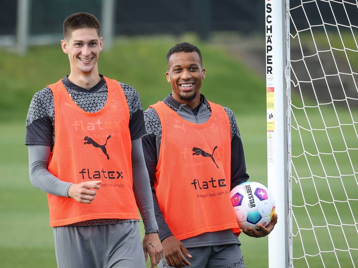 Die Gladbach-Profis Alassane Plea und Tomas Cvancara stehen lachend nebeneinander auf dem Trainingsplatz.