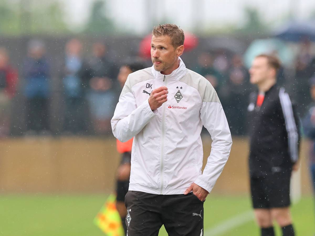 Oliver Kirch im Regen in einer Gladbach-Jacke.