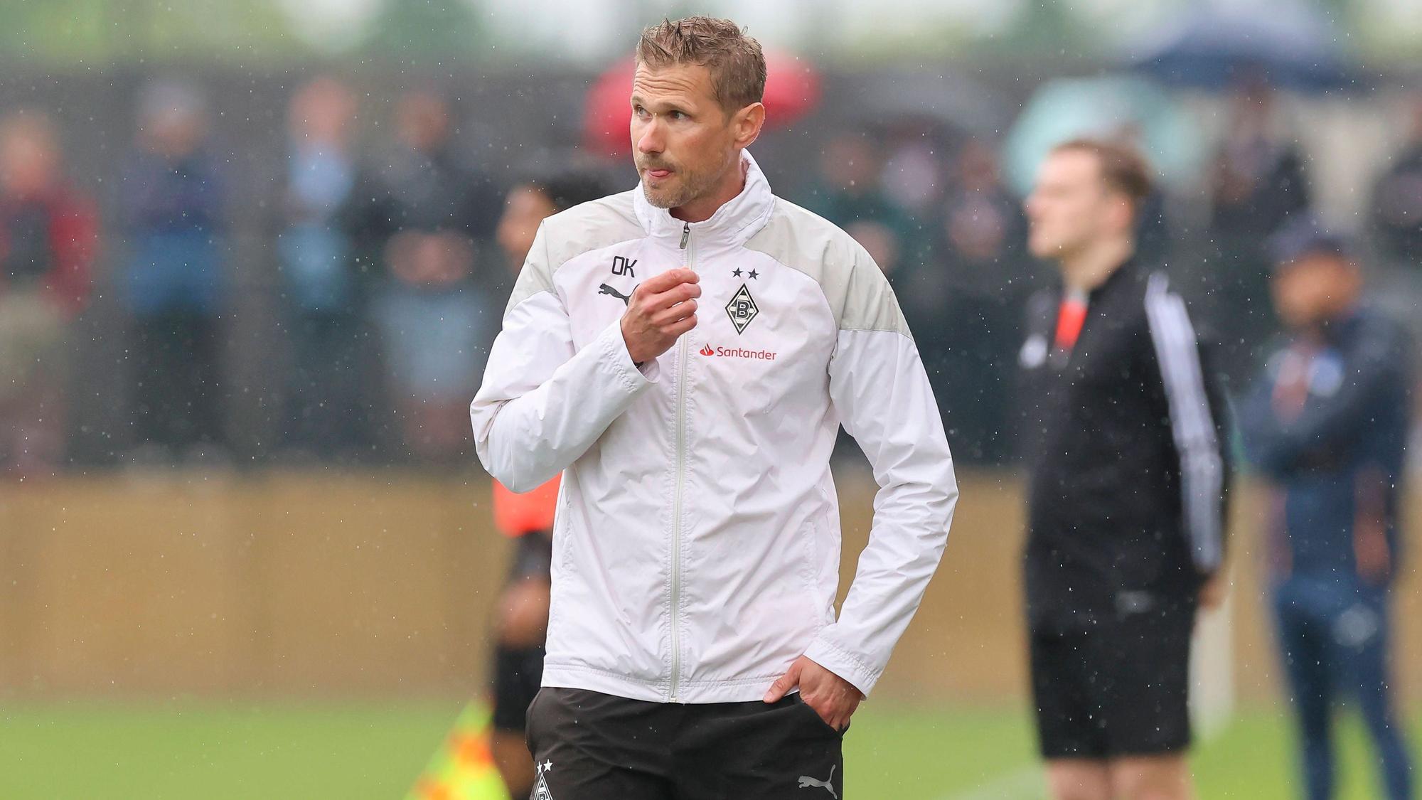 Oliver Kirch im Regen in einer Gladbach-Jacke.