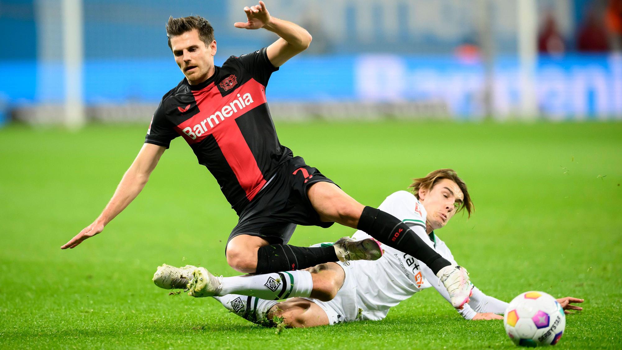 Bayer Leverkusens Jonas Hofmann wird von Borussia Mönchengladbachs Florian Neuhaus abgegrätscht.