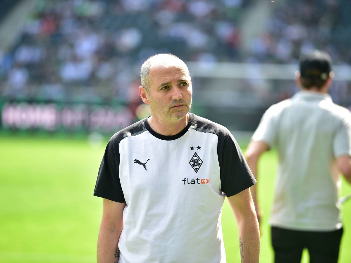 Oliver Neuville im Borussia-Shirt neben dem Platz.