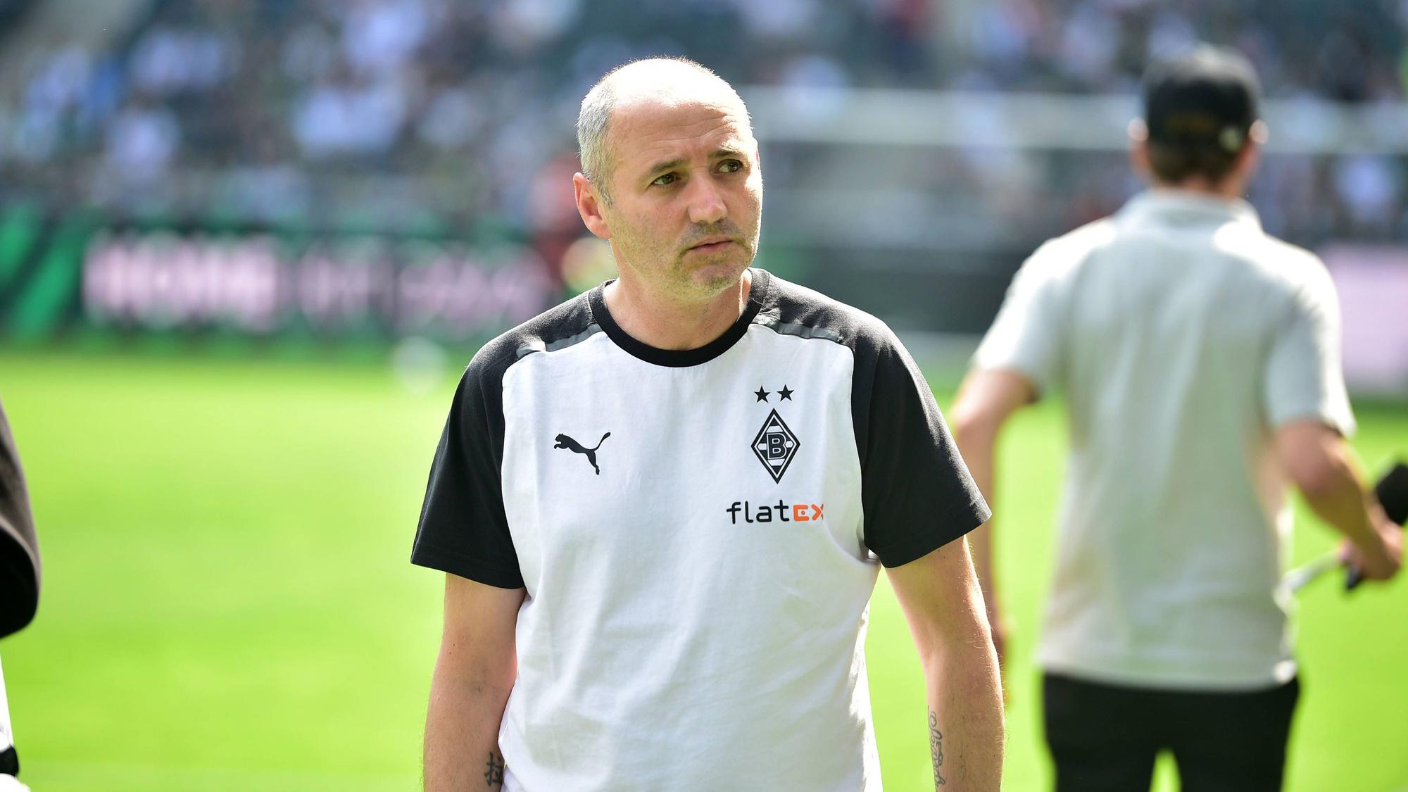 Oliver Neuville im Borussia-Shirt neben dem Platz.