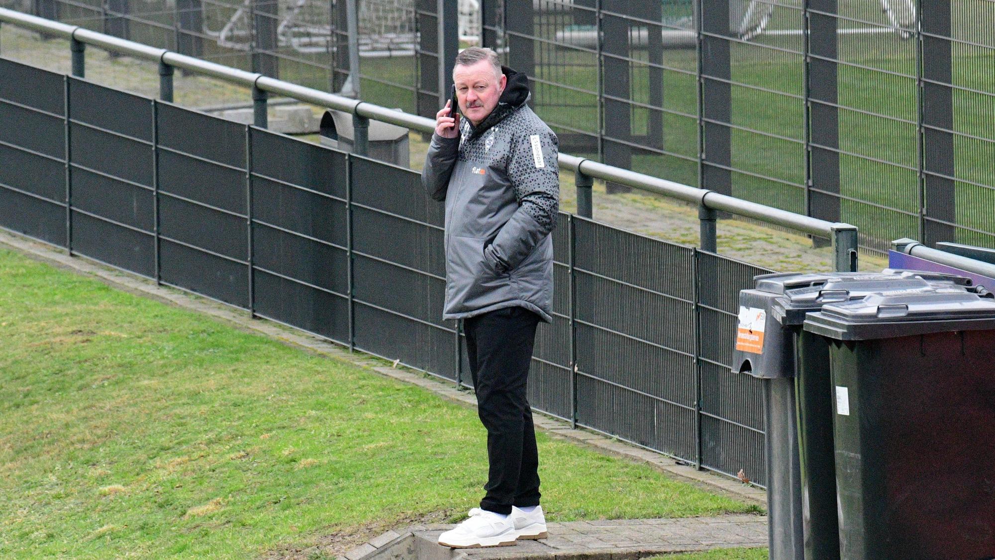 Roland Virkus telefoniert auf dem Trainingsplatz.