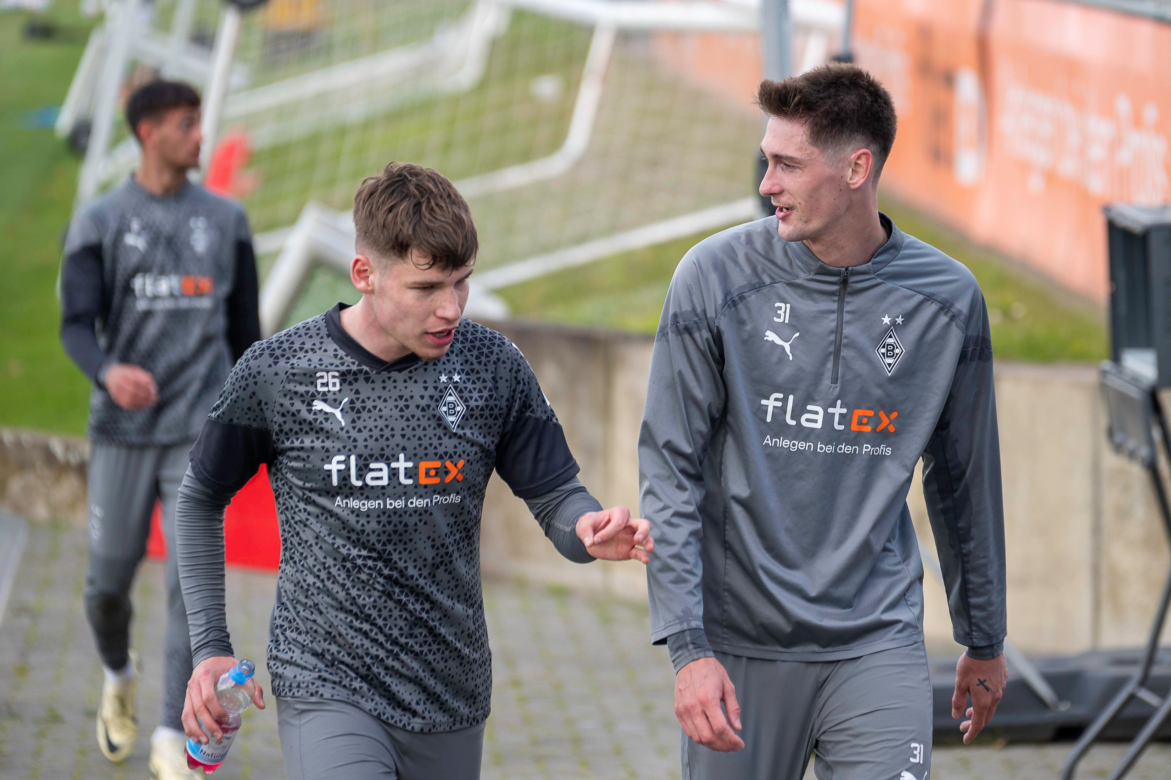 Die Gladbacher Spieler Lukas Ullrich und Tomas Cvancara unterhalten sich auf dem Weg zum Training.