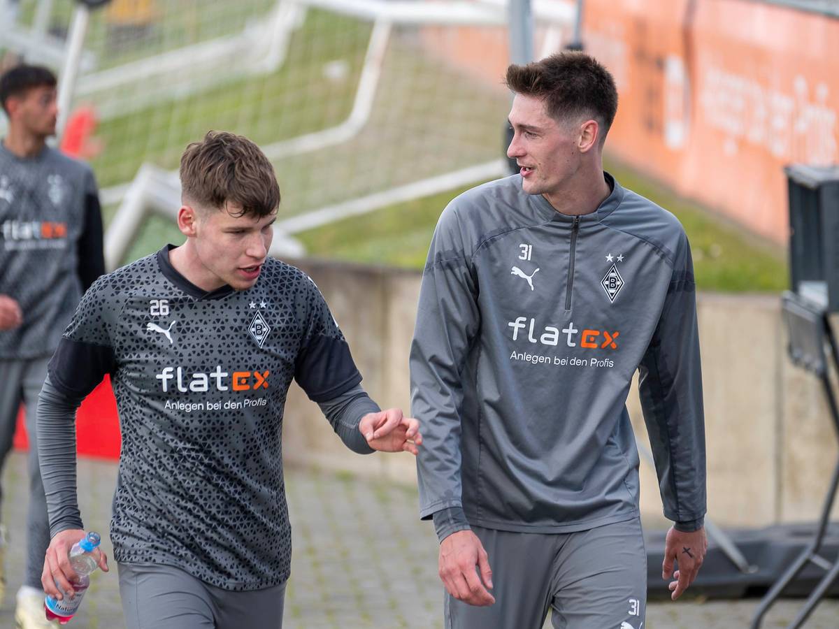 Die Gladbacher Spieler Lukas Ullrich und Tomas Cvancara unterhalten sich auf dem Weg zum Training.