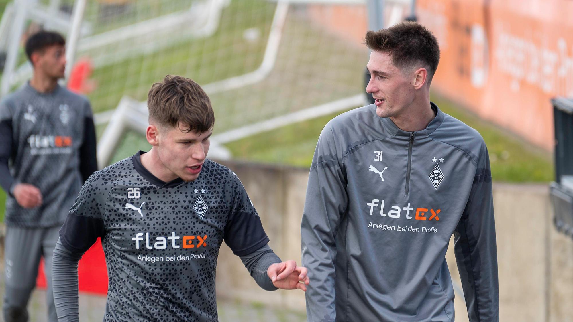 Die Gladbacher Spieler Lukas Ullrich und Tomas Cvancara unterhalten sich auf dem Weg zum Training.