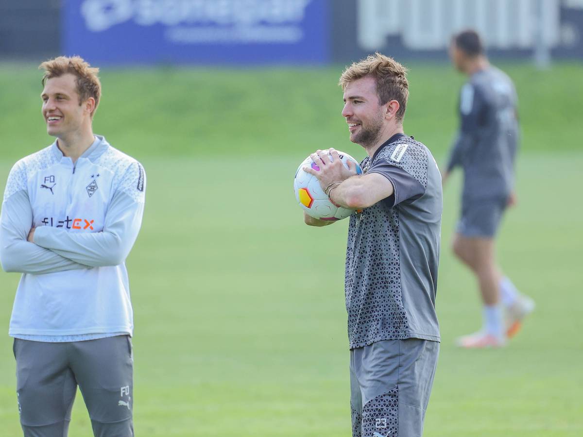 Gladbachs Mittelfeldspieler Christoph Kramer und Torwarttrainer Fabian Otte stehen gemeinsam lachend auf dem Trainingsplatz.