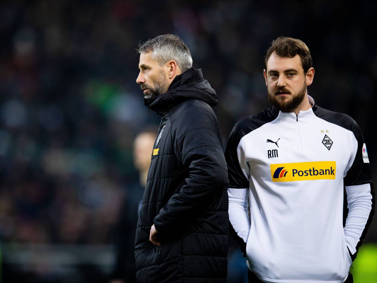 René Maric steht hinter Marco Rose in einer Gladbach-Jacke.