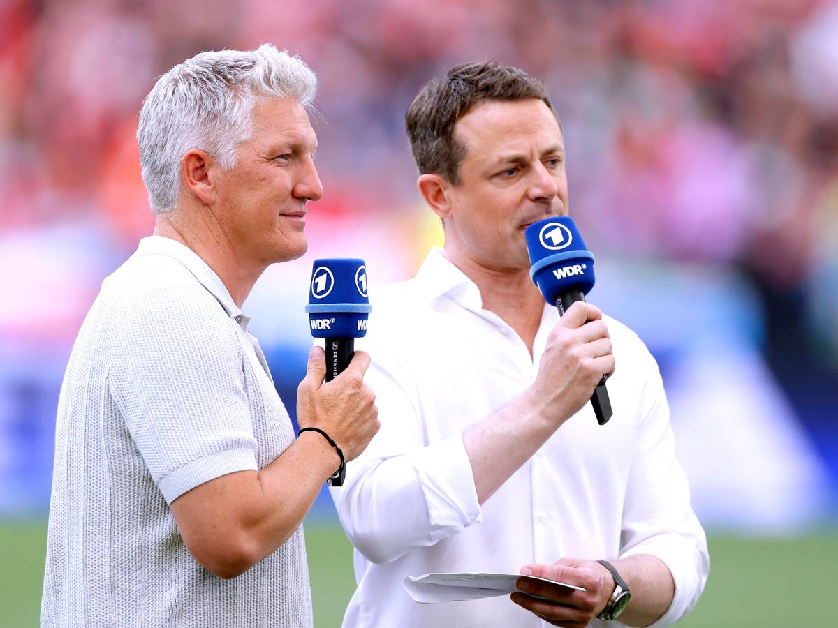 TV-Experte Bastian Schweinsteiger und ARD-Moderator Alexander Bommes stehen beim EM-Spiel Ungarn gegen Deutschland am Platz und sprechen in ihre Mikrofone.