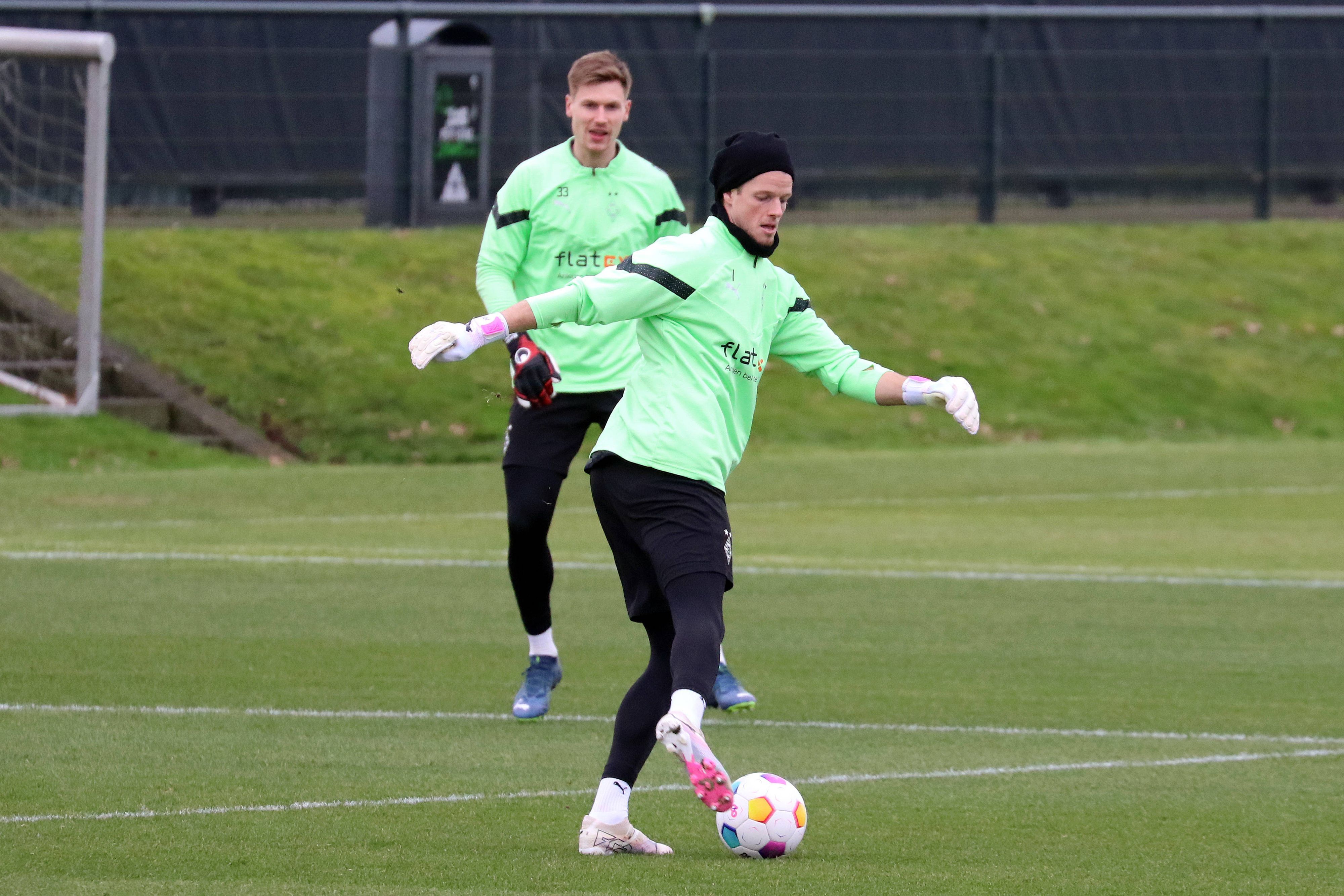 Borussia Mönchengladbachs Keeper Jonas Omlin passt den Ball im Training, Konkurrent Moritz Nicolas schaut im Hintergrund zu.