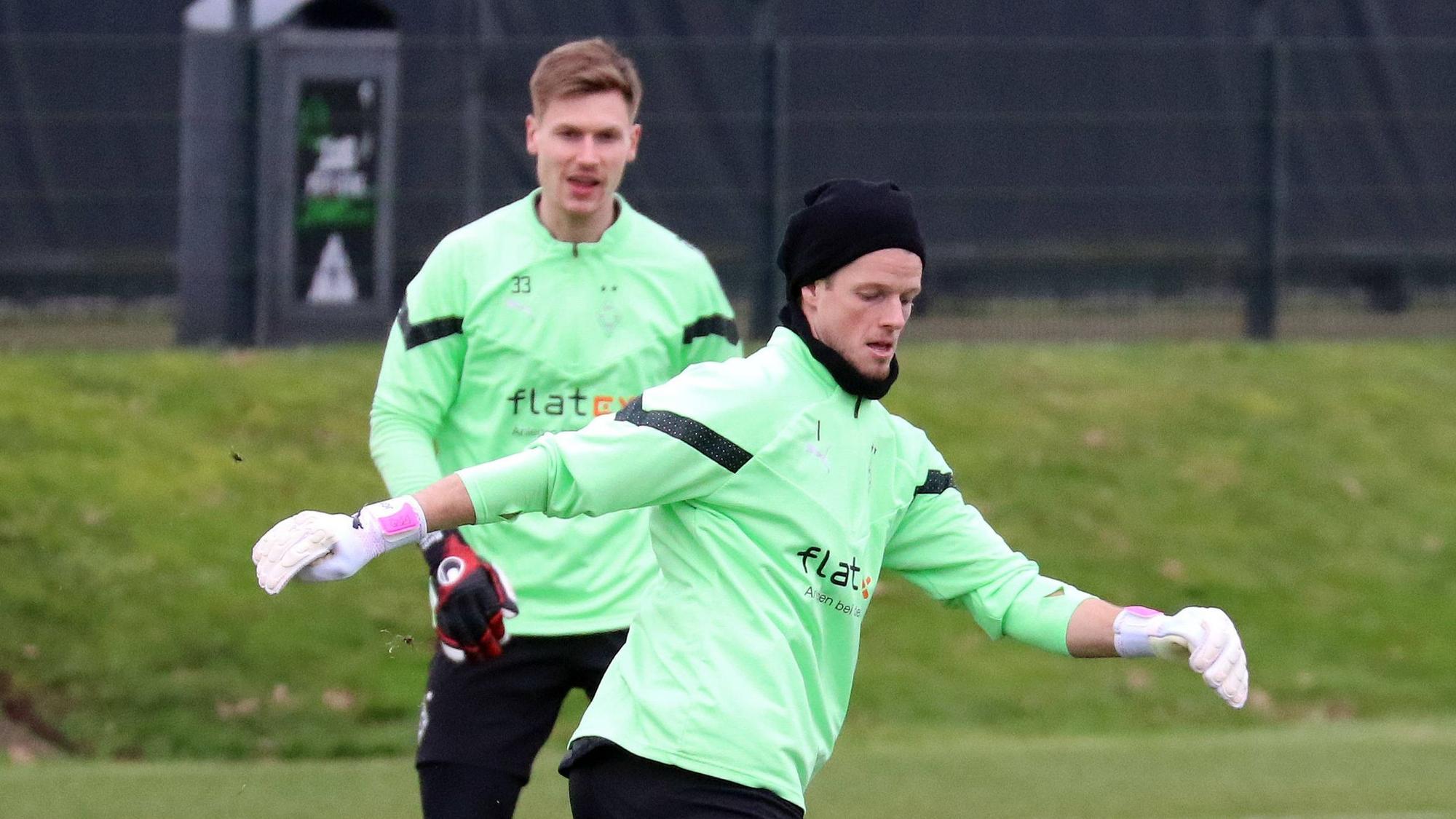 Borussia Mönchengladbachs Keeper Jonas Omlin passt den Ball im Training, Konkurrent Moritz Nicolas schaut im Hintergrund zu.