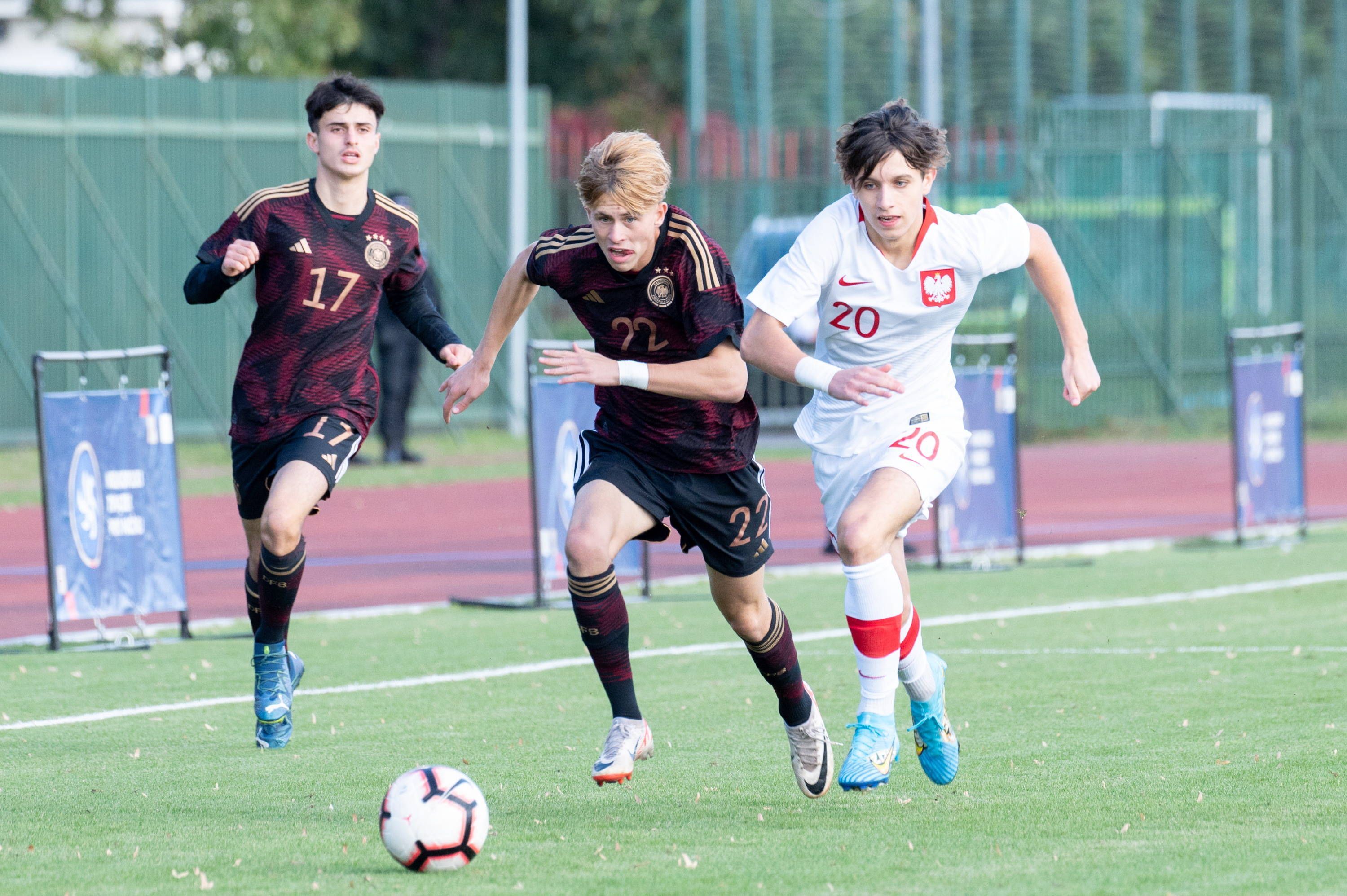 Deutschlands Noah Birkenpesch treibt den Ball, Polens Jakub Peret verfolgt ihn.