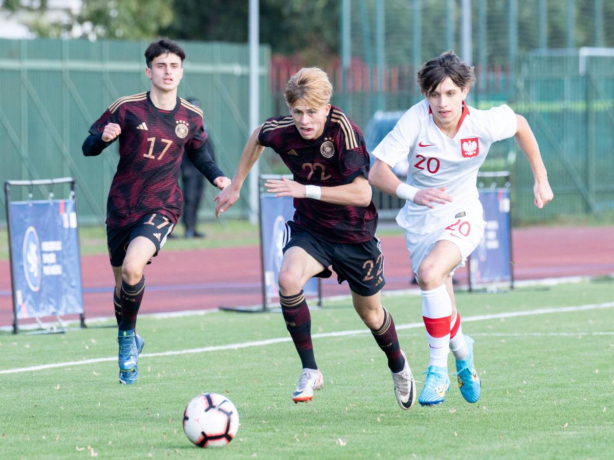 Deutschlands Noah Birkenpesch treibt den Ball, Polens Jakub Peret verfolgt ihn.