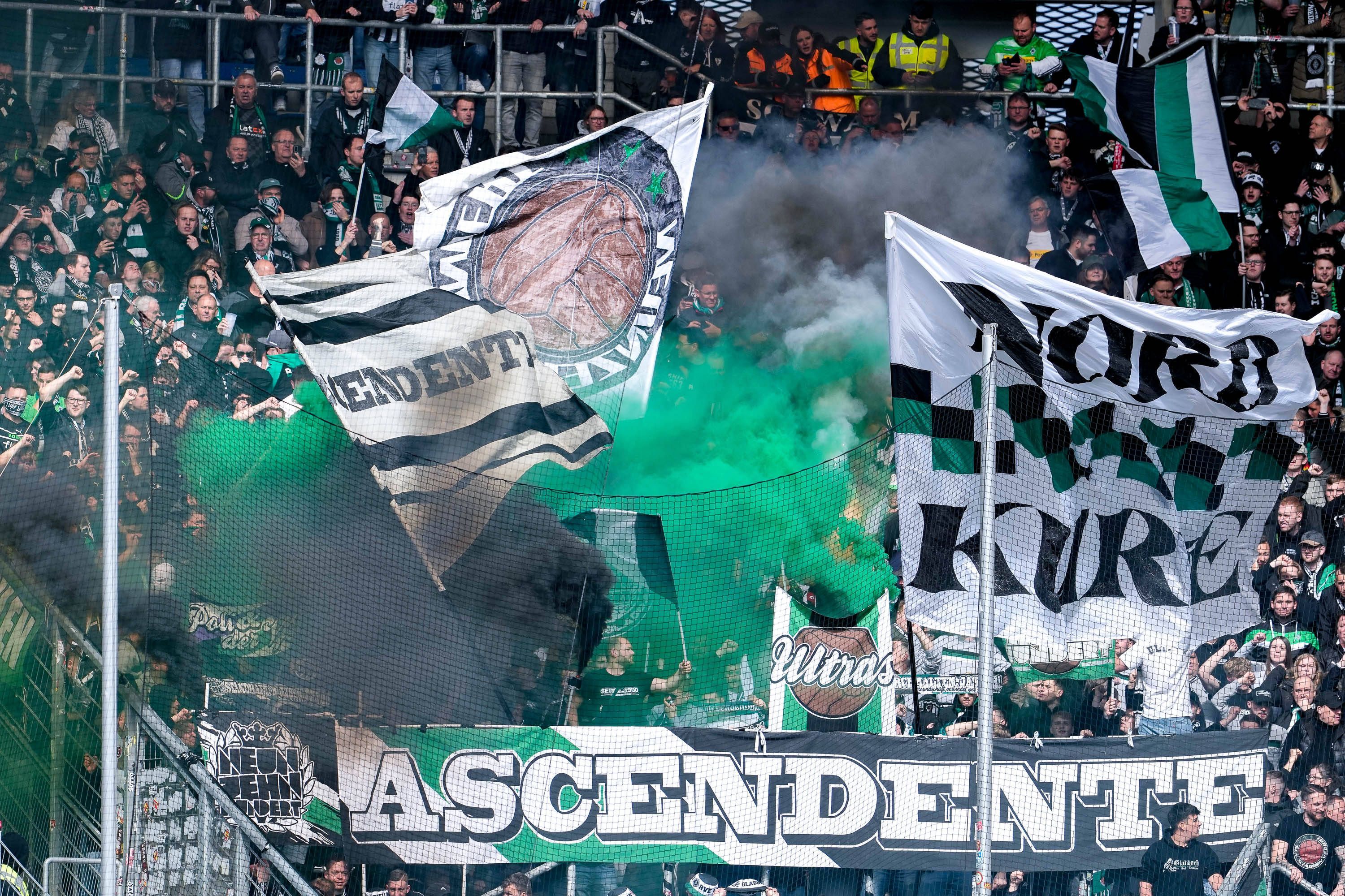 Fans von Borussia Mönchengladbach zünden während des Bundesliga-Spiels bei der TSG Hoffenheim im Gäste-Block Pyrotechnik.