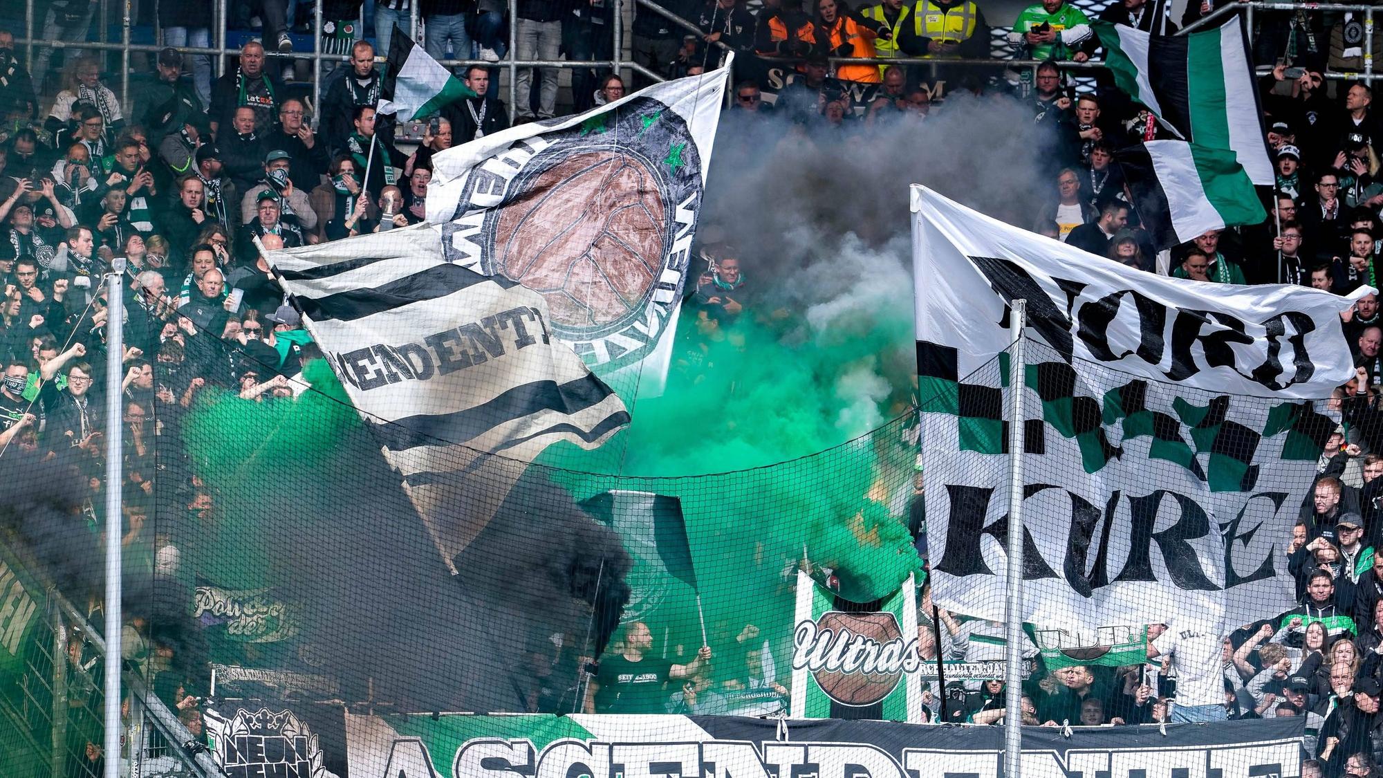 Fans von Borussia Mönchengladbach zünden während des Bundesliga-Spiels bei der TSG Hoffenheim im Gäste-Block Pyrotechnik.