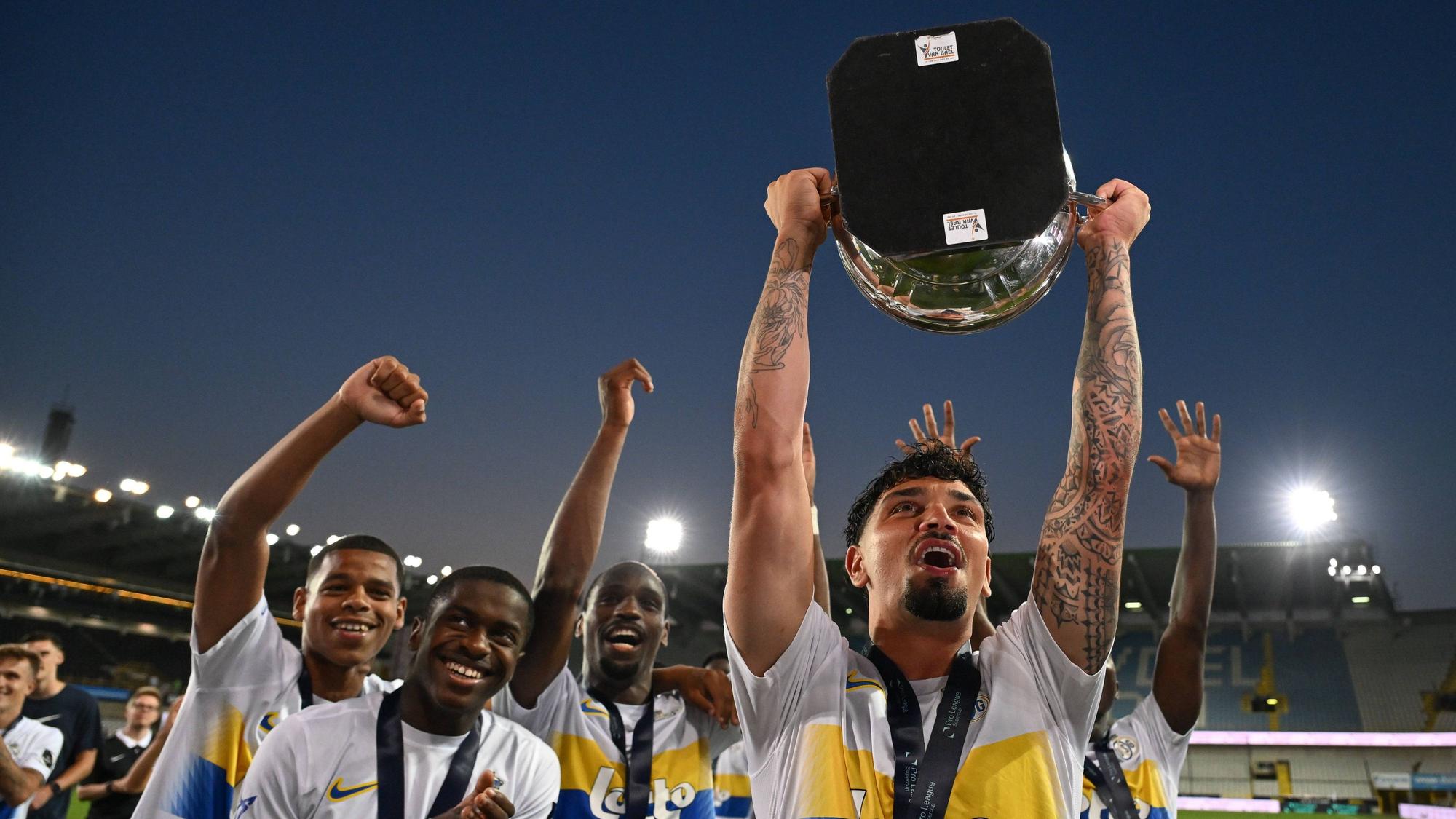 Cameron Puertas hält den belgischen Pokal in der Hand.