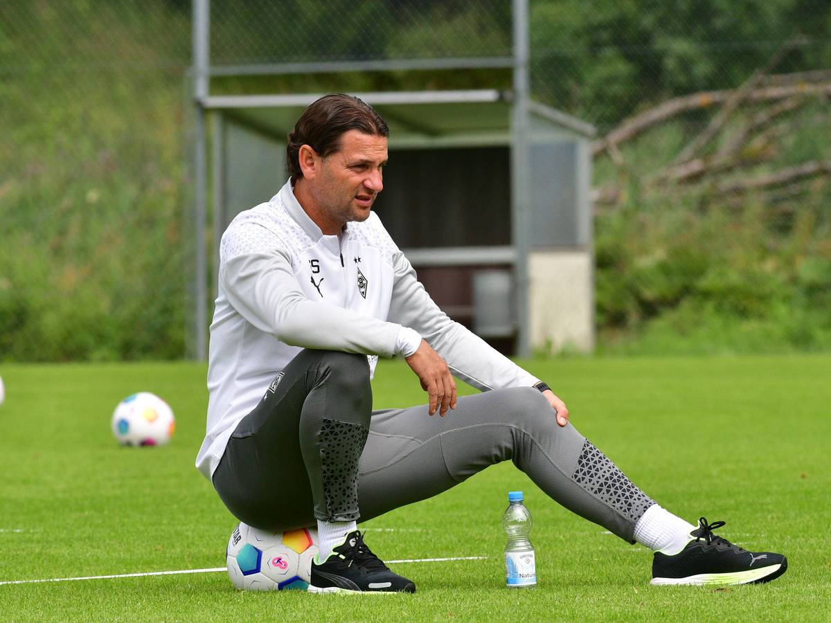 Borussia Mönchengladbachs Trainer Gerardo Seoane sitzt auf einem Ball und beobachtet die Trainingseinheit.