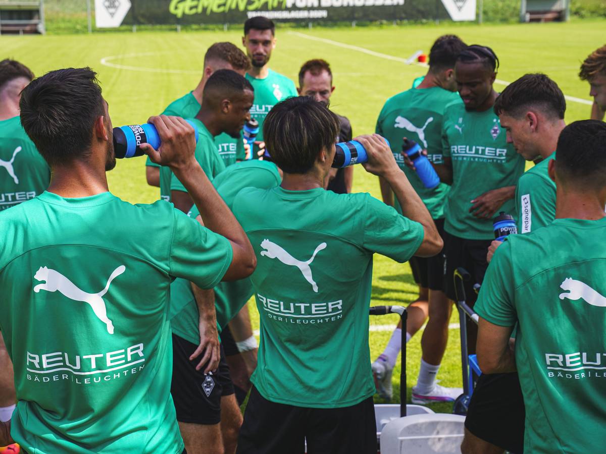 Die Spieler von Borussia Mönchengladbach trinken aus ihren Wasserflaschen.
