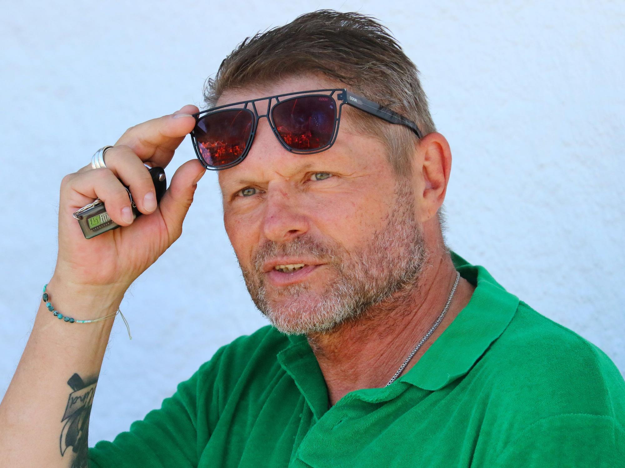 Uli Borowka schiebt sich die Sonnenbrille auf die Stirn.