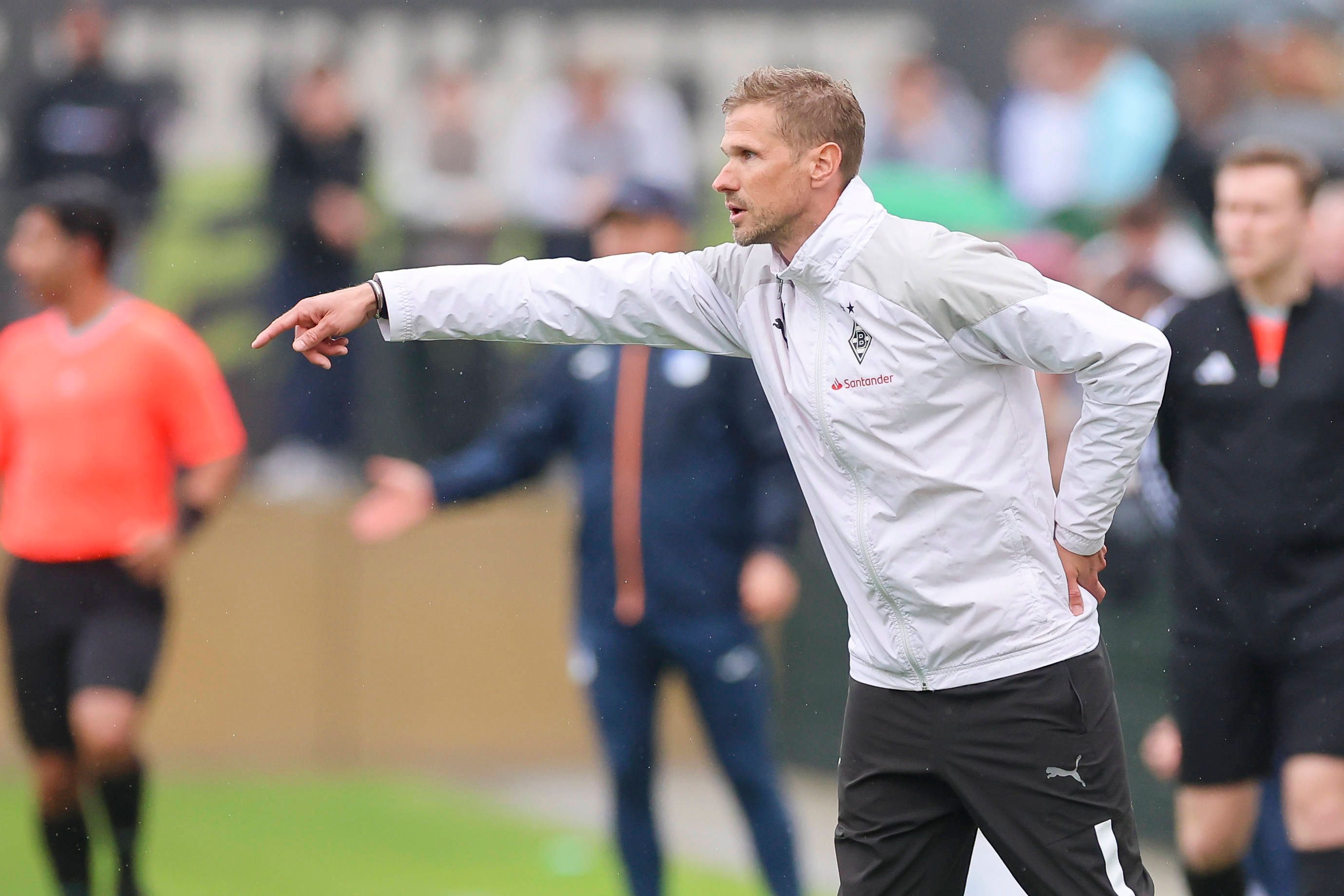 Oliver Kirch coacht während eines Spiels und streckt seinen Arm heraus.