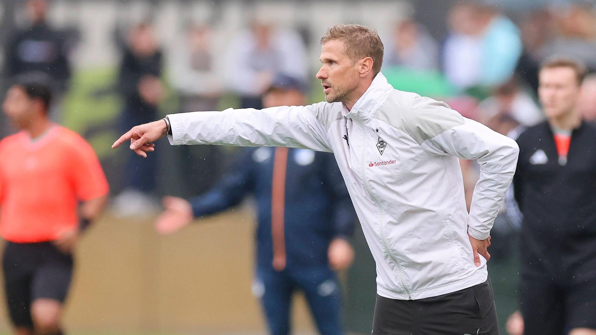 Oliver Kirch coacht während eines Spiels und streckt seinen Arm heraus.