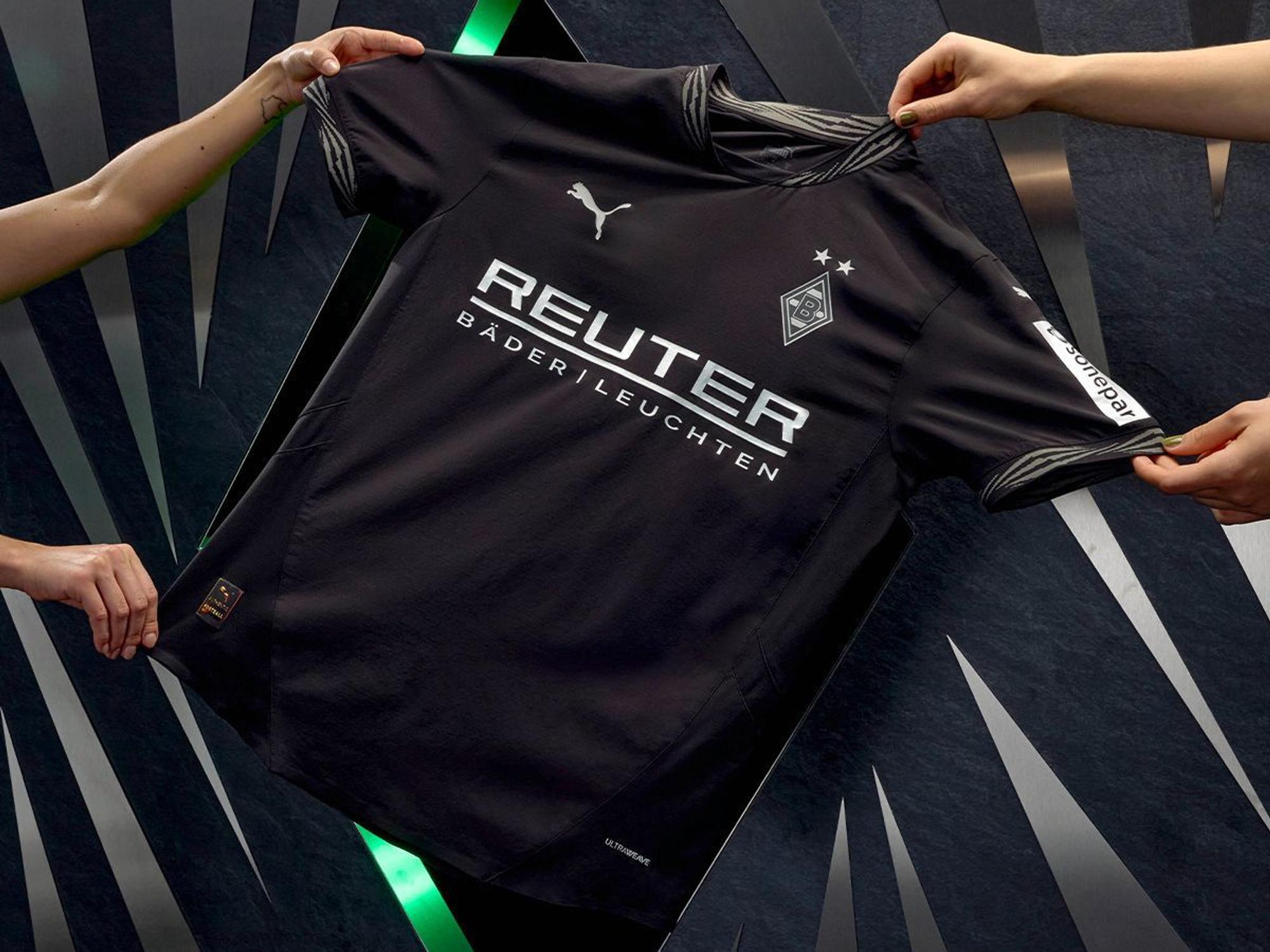 Vier Hände präsentieren das neue Ausweich-Trikot von Borussia Mönchengladbach.
