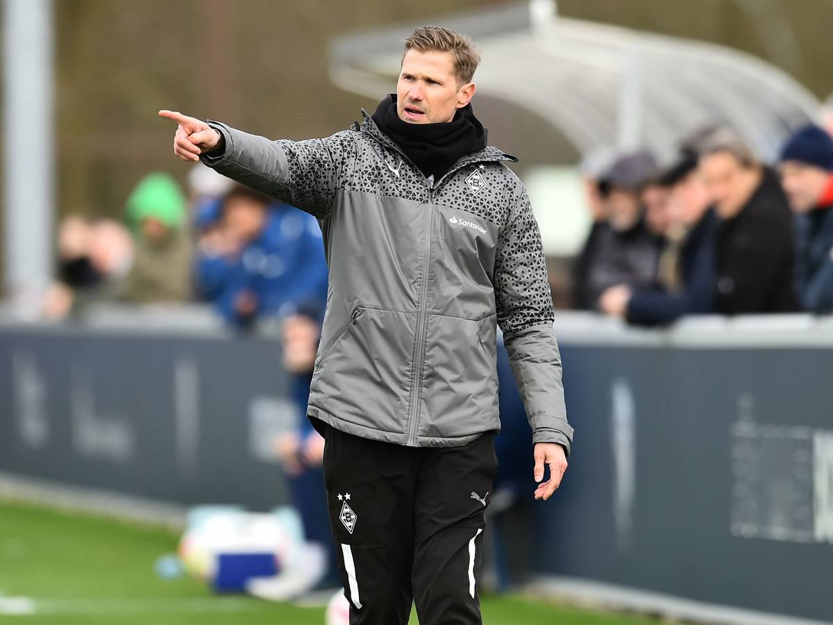 Oliver Kirch an der Seitenlinie hebt den rechten Arm.