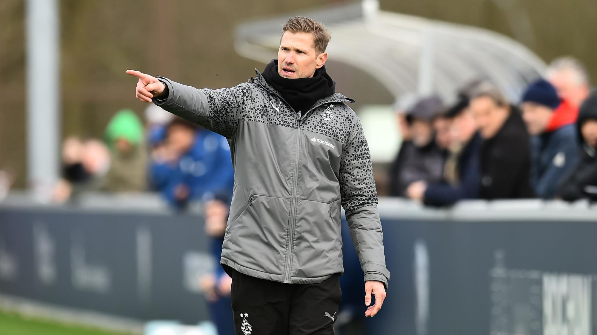 Oliver Kirch an der Seitenlinie hebt den rechten Arm.