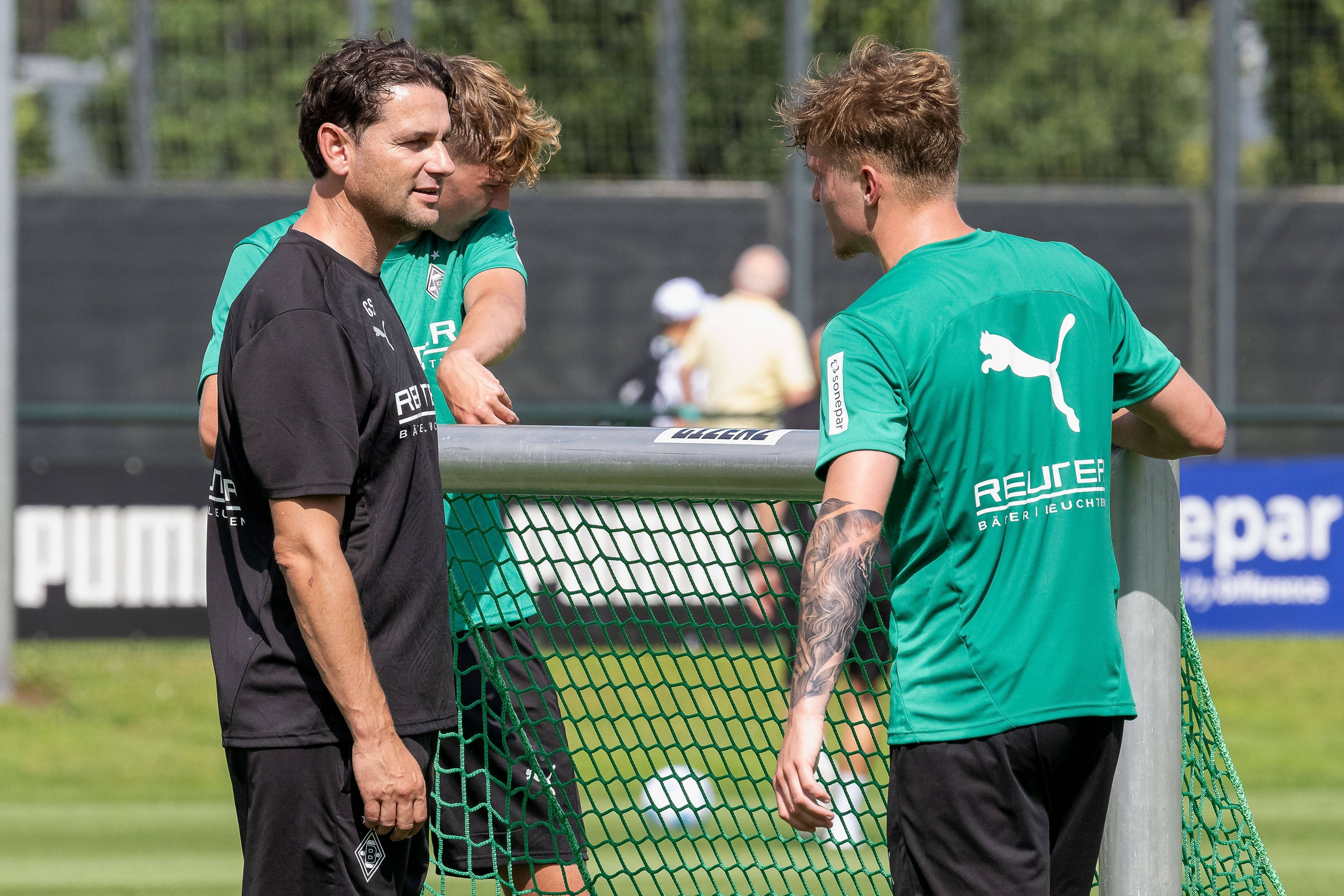 Gerardo Seoane und Luca Netz tragen ein kleines Tor beim Training.