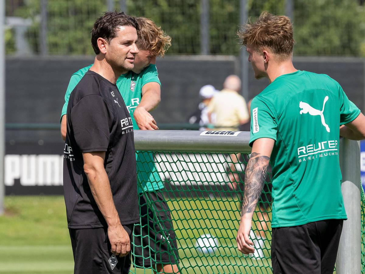 Gerardo Seoane und Luca Netz tragen ein kleines Tor beim Training.