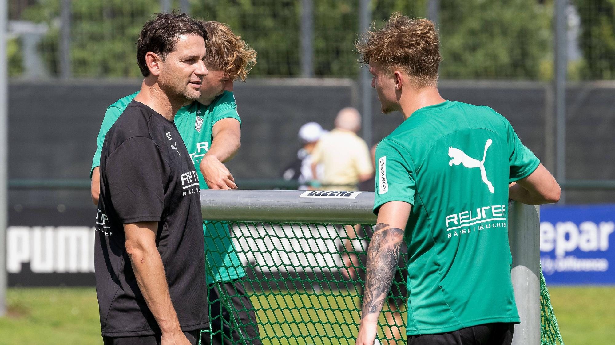Gerardo Seoane und Luca Netz tragen ein kleines Tor beim Training.
